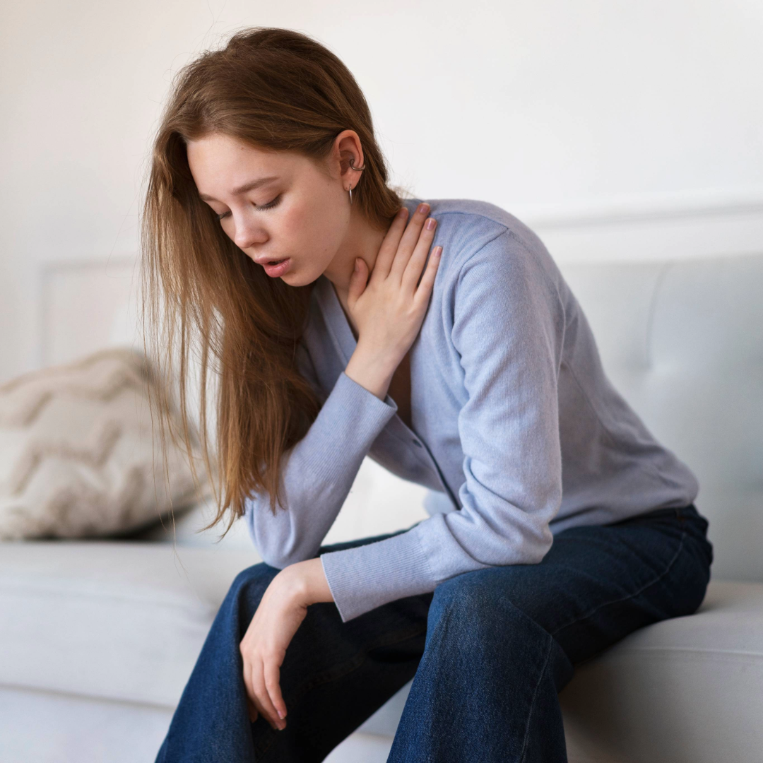 Une femme qui a mal et qui se tient la gorge